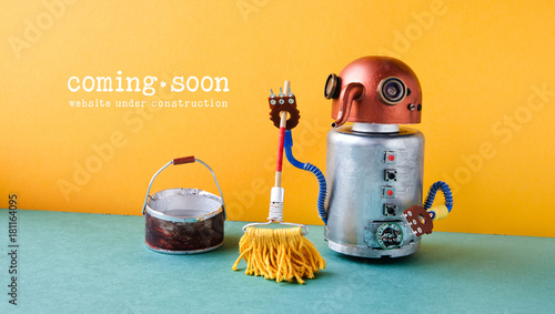 Web site under construction Coming Soon template page. Robot washer with mop and bucket of water, orange wall green floor interior photo