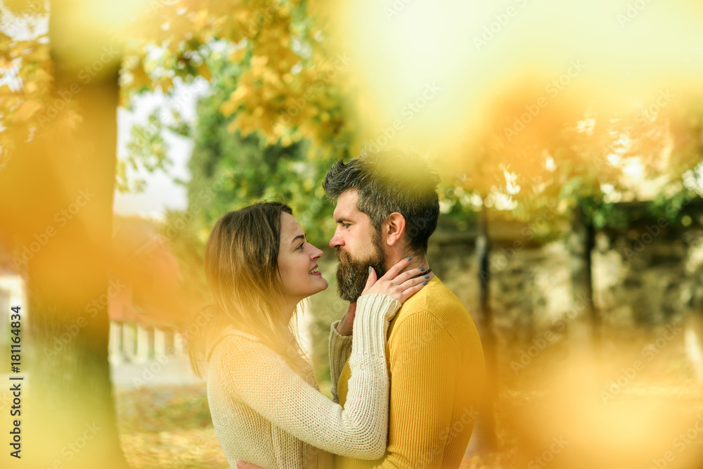 Fototapeta premium Man and woman at yellow tree leaves.