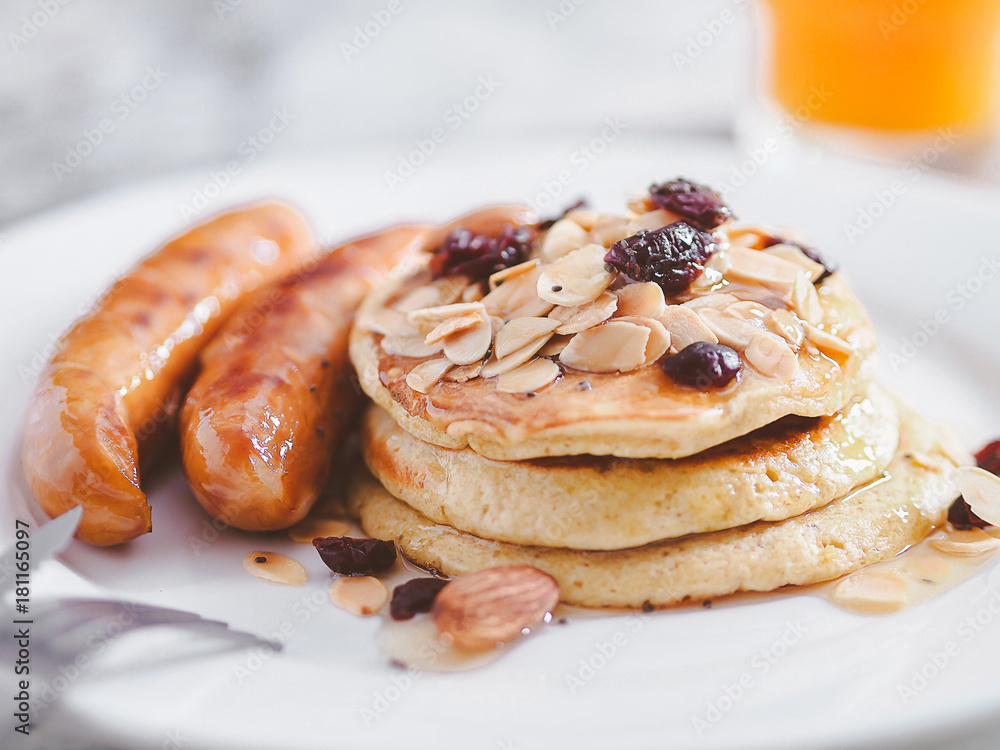 Breakfast Pancake and Sausage Top with Almond and Raisin on white plate