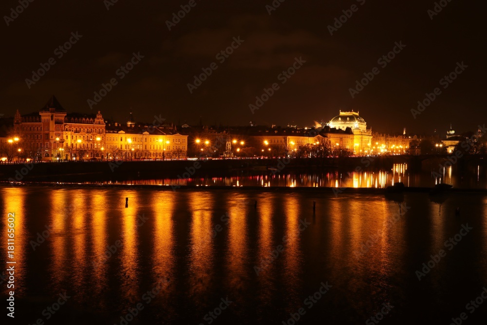 Prague at night , panoramic night view from Charles bridge to the illuminated national theatre