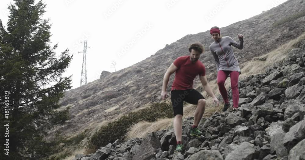 Athlete woman and man walking down rocky path.Real people runner sport training in autumn or winter in wild mountain outdoors nature, bad foggy weather.4k 60p slow motion video Athlete woman and man walking down rocky path.Real people runner sport training in autumn or winter in wild mountain outdoors nature, bad foggy weather.4k 60p slow motion video