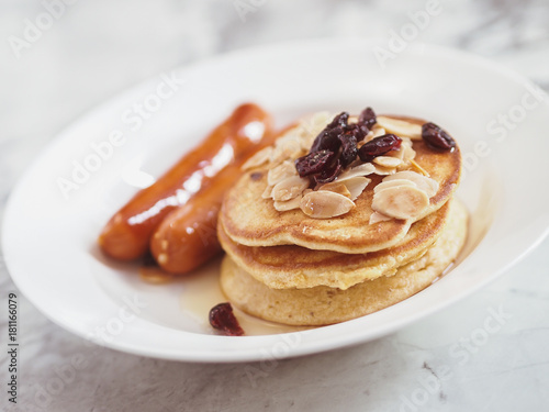 Breakfast Pancake and Sausage Top with Almond and Raisin on white plate