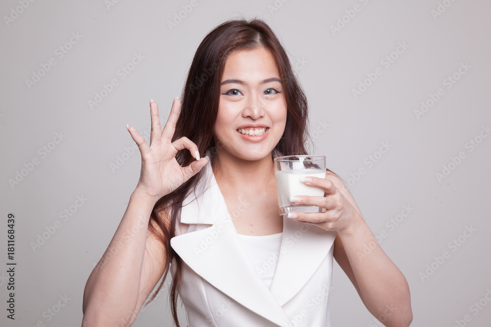 Healthy Asian woman drinking a glass of milk show OK sign. Healthy Asian woman drinking a glass of milk show OK sign.