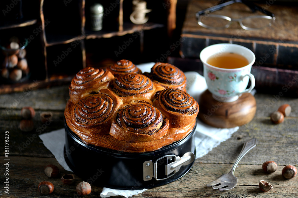 Buns with poppy seeds, cinnamon and nuts on an old wooden background. Rustic style. Buns with poppy seeds, cinnamon and nuts on an old wooden background. Rustic style.