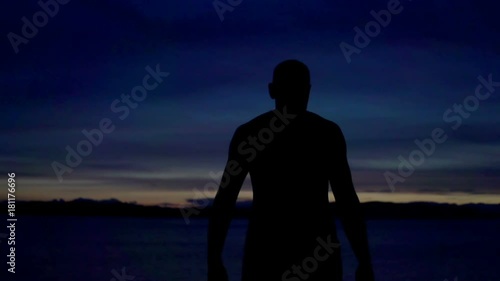 Silhouette man standing in exotic place, steadycam shot, slow motion shot at 240fps
 photo