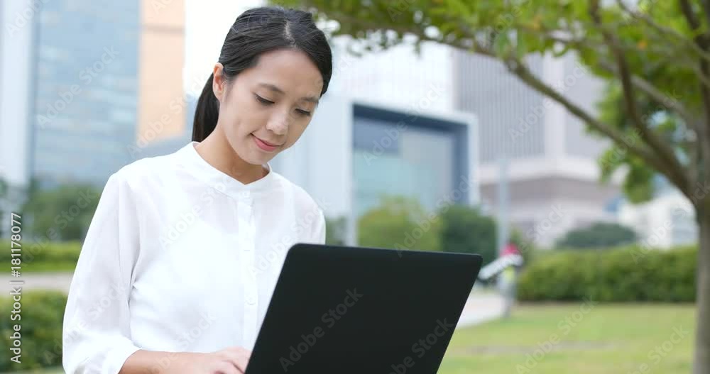 Business woman use of notebook computer in city Business woman use of notebook computer in city