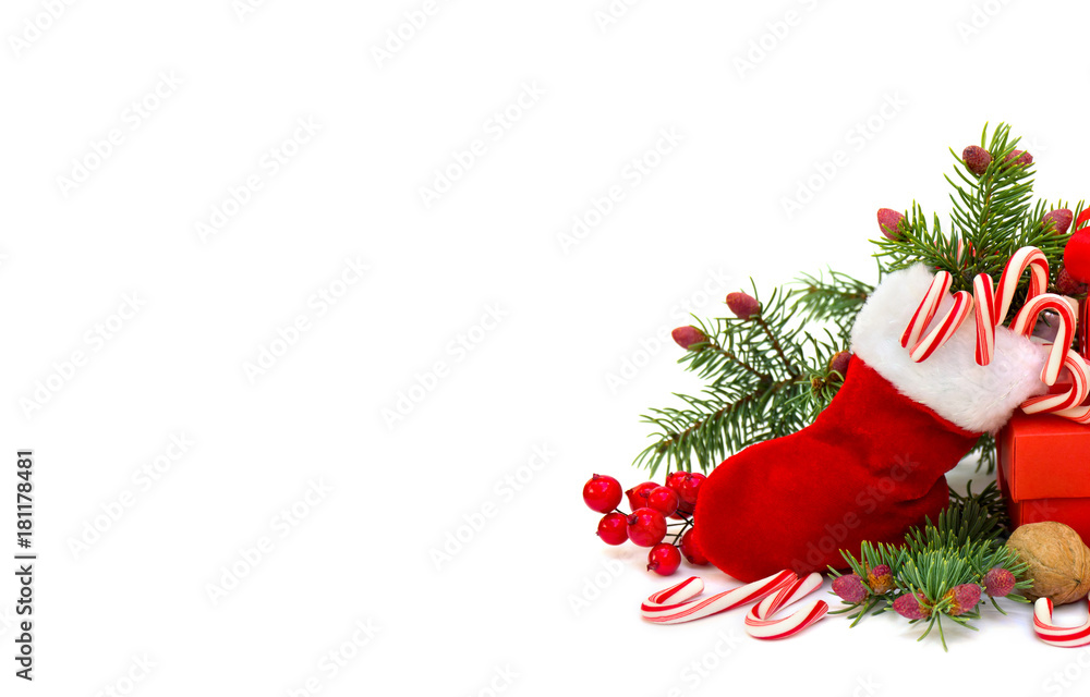 Christmas decoration with christmas stocking, branch of spruce, candies, walnut, berry, gift box on white background with space for text
