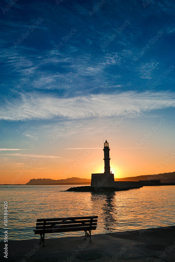 Sunrise view from the port of Chania Crete in Greece. Sun rises behind the lighthouse of the port Sunrise view from the port of Chania Crete in Greece. Sun rises behind the lighthouse of the port