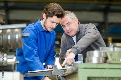 apprentice being shown how to cut sheet metal