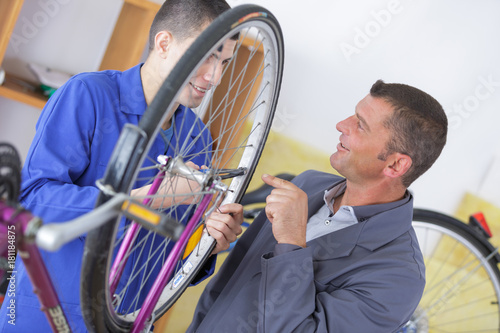 apprentice looking at bikes wheel