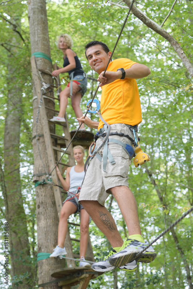 friends on a rope climbing in the adventure park