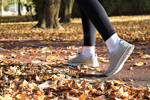 Recreation in the park during fall season - jogging and walking