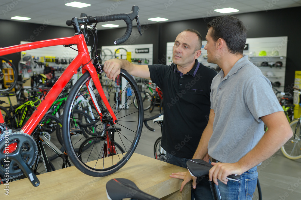 client and seller discussing bicycle in store client and seller discussing bicycle in store