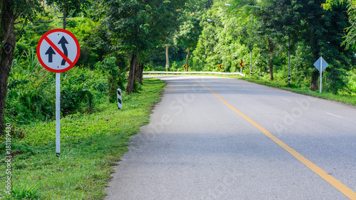 "Do not overtake" traffic sign board on the winding road in Thailand.