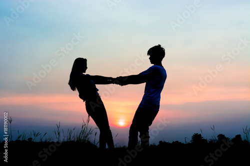 Obraz na plátně silhouette of romantic couple at the sunset time on meadow