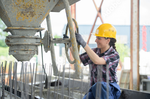 woman operator pouring mixture in the cement moulding photo