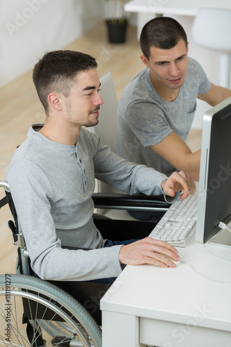 handicapped teenager doing his homework with friend