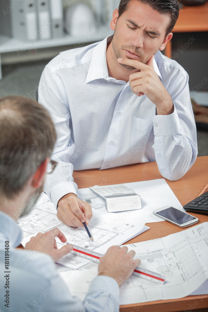 Fototapeta premium Man discussing blueprints, frowning