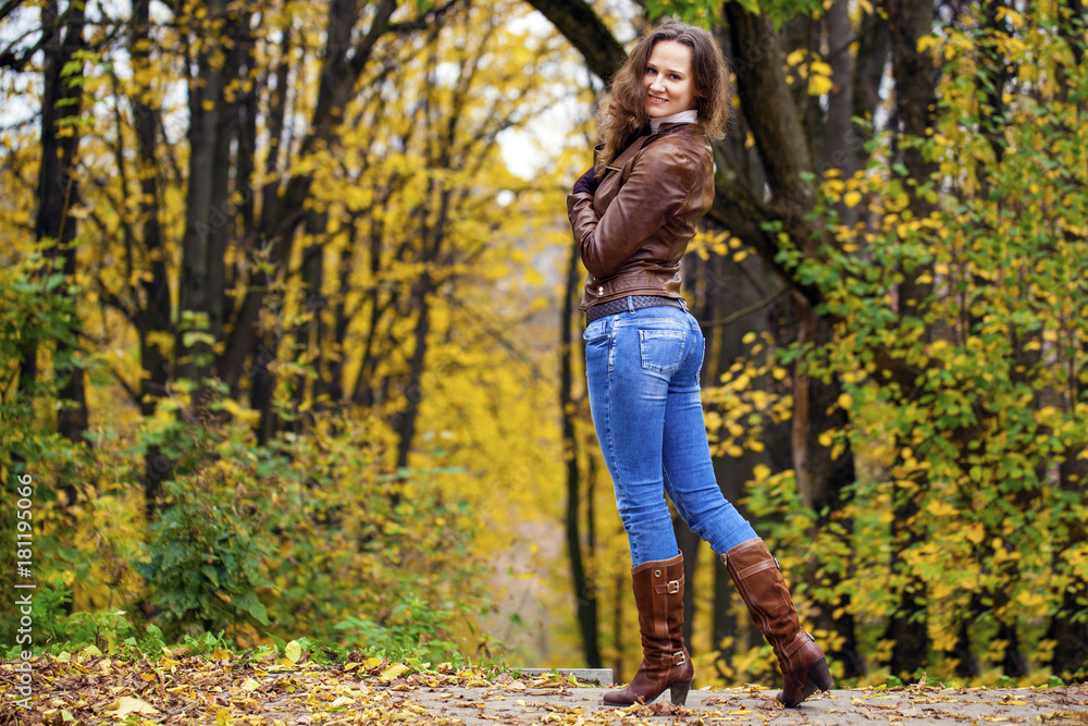 Autumn fashion image of young woman walking in the park Autumn fashion image of young woman walking in the park