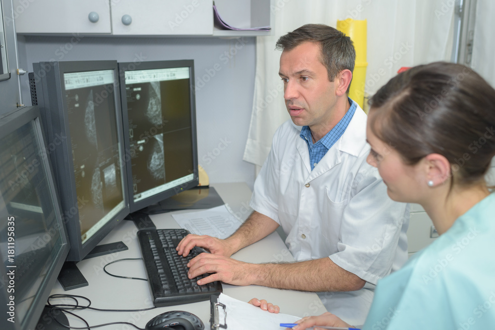 Obraz premium doctors checking xray on a computers screen on a desk