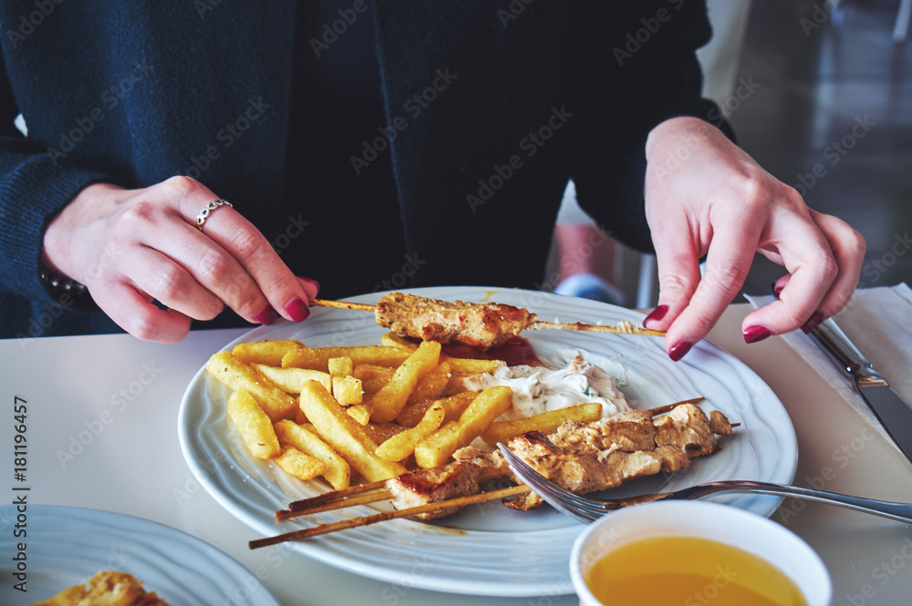 Woman eating meat with fries