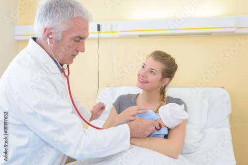 mother holding baby for pediatrician to examine