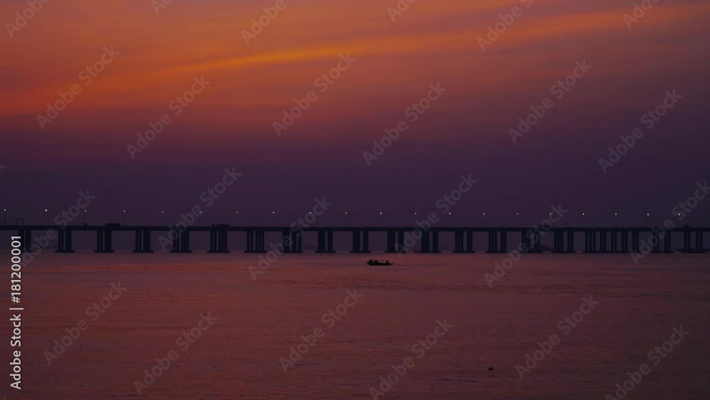 riesige moderne Brücke über die Bucht von Shenzhen, China, mit einem kleinem Fischerboot im Vordergrund nach Sonnenuntergang riesige moderne Brücke über die Bucht von Shenzhen, China, mit einem kleinem Fischerboot im Vordergrund nach Sonnenuntergang