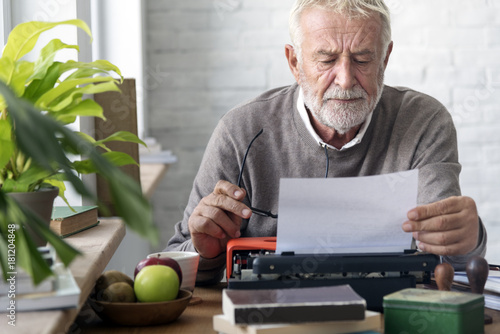 Old man typing on a typewriter photo