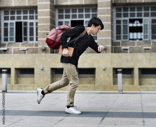 Fotografie Asian Guy Running in a Hurry watching Time