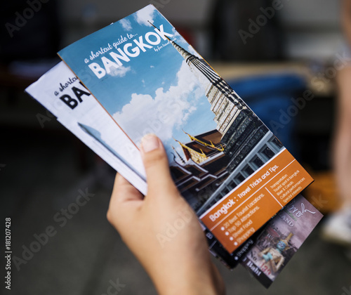 Closeup of hand holding Bangkok travel guide brochure photo