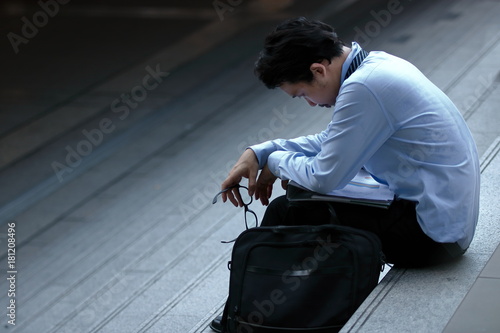 Frustrated stressed young Asian business man feeling strain or tried or disappointed at staircase.