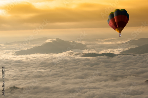 Beautiful landscape of Foggy morning in the Mountains with hot-air balloons flying over the mountain.