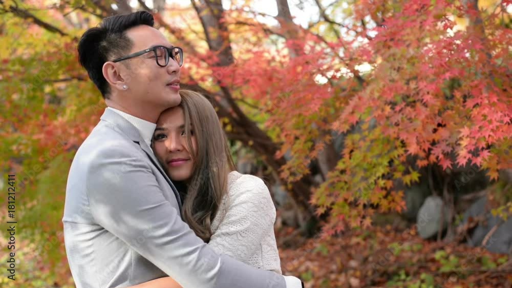 Happy couple hugging in the red maple autumn scene Happy couple hugging in the red maple autumn scene