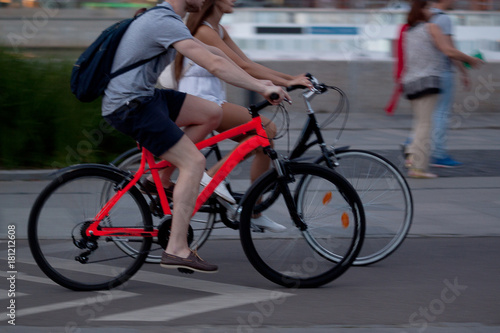 a girl and a guy spend time together riding on bicycles in the summer evening city