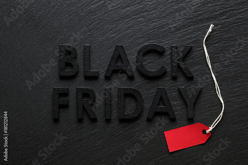 Black Friday text with red sale tag on slate background