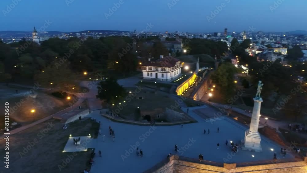 View of city fortress above monument in night View of city fortress above monument in night