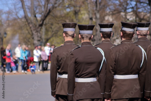 Łotwa, Ryga, oficjalna ceremonia z udziałem łotewskiej armii, święto narodowe Łotwy, grupa żołnierzy, tyłem, na drugim planie niewyraźna grupa ludzi uczestnicząca w święcie, park