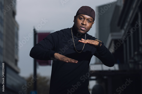 Brutal man rapper posing in city photo