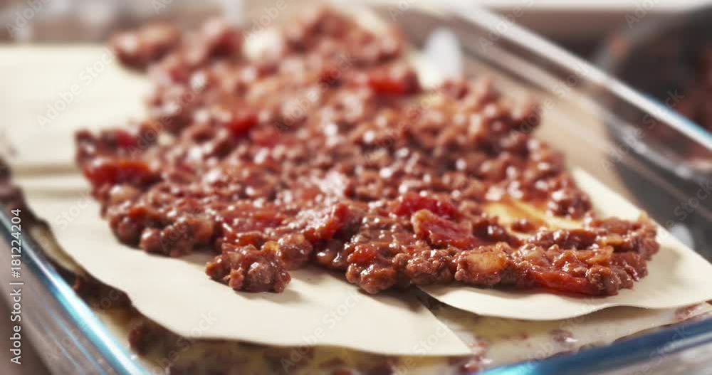 Slide shot of preparing traditional italian lasagna adding bolognese sauce Slide shot of preparing traditional italian lasagna adding bolognese sauce