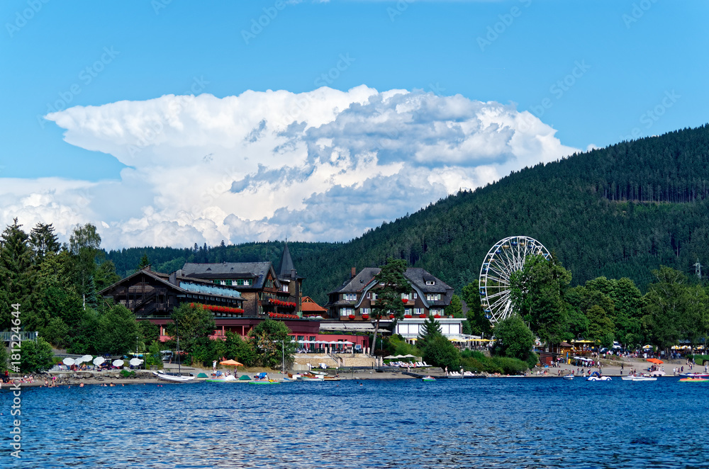 Touristic resorts at the lake Titisee in Black forest national park Germany (Schwarzwald). Panoramic view at the traditional buildings and Ferris Wheel at the famous promenade.