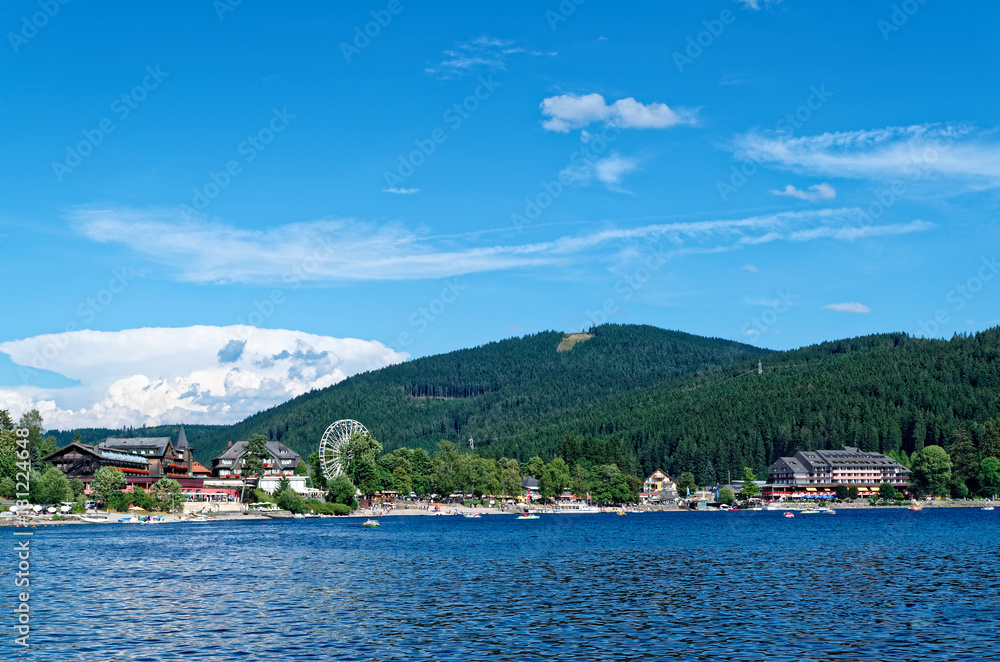 Traditional houses and ferris wheel on the promenade of the Titi lake (Titisee), Black Forest, Germany