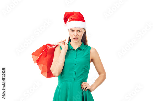 Studio portrait of young woman in Santa hat posing with shopping bags on white background
