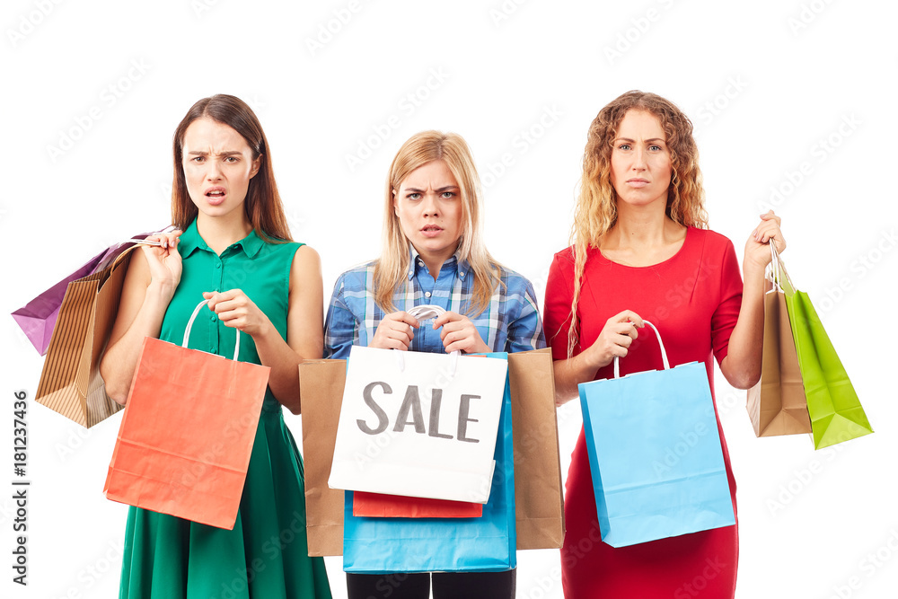 Portrait of three young woman holding bunches of multi-colored shopping bags after sale Portrait of three young woman holding bunches of multi-colored shopping bags after sale