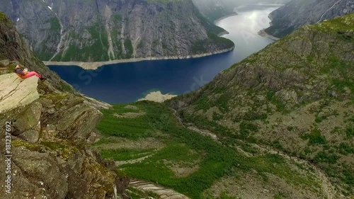 Trolltunga. Norway. The guy and the girl sitting on the edge of the Trolltunga. aerial vie. beautiful landscape of Norway