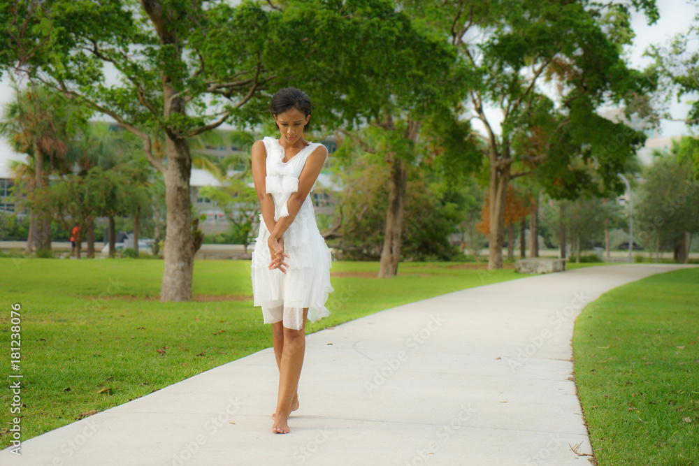A beautiful African-looking girl with black short hair in a dancing pose dressed in a white dress A beautiful African-looking girl with black short hair in a dancing pose dressed in a white dress