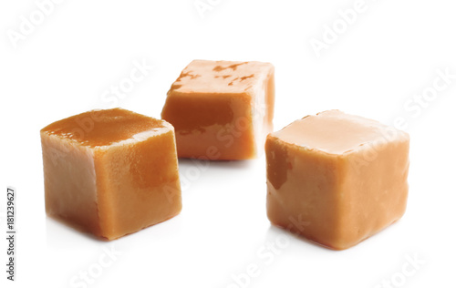 Tasty caramel candies on white background