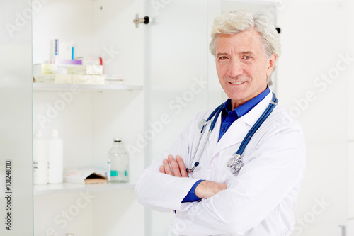 Confident doctor or pharmacist in whitecoat crossing his arms on chest