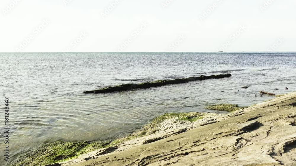 The landscape of the sea and the ship on the horizon and the coastal cleft go into the sea The landscape of the sea and the ship on the horizon and the coastal cleft go into the sea