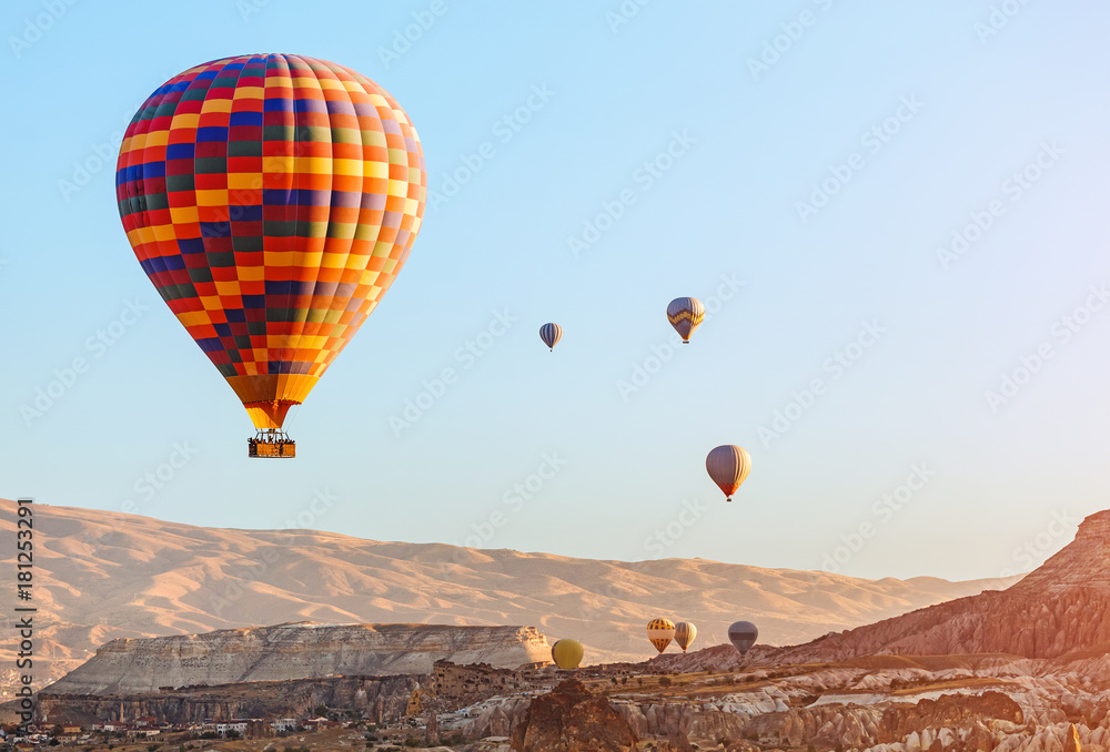 Fototapeta premium Colorful Hot air balloon flying over rock landscape at Cappadocia Turkey