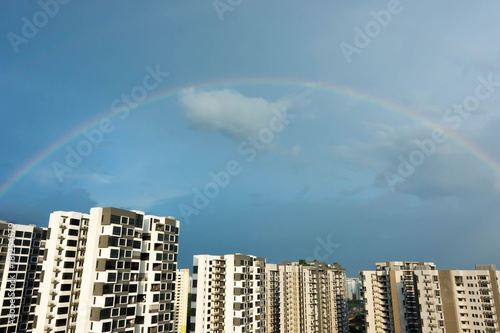 Skyline photo of condominium with rainbow and blue sky